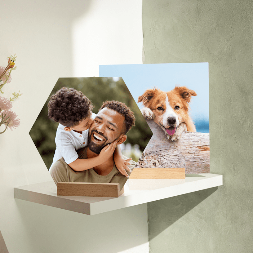 Eine sechseckige Fotokachel mit Aufsteller und dem Bild eines Vaters mit seinem Sohn sowie eine quadratische Fotokachel zum Aufstellen mit einem Hundefoto. 