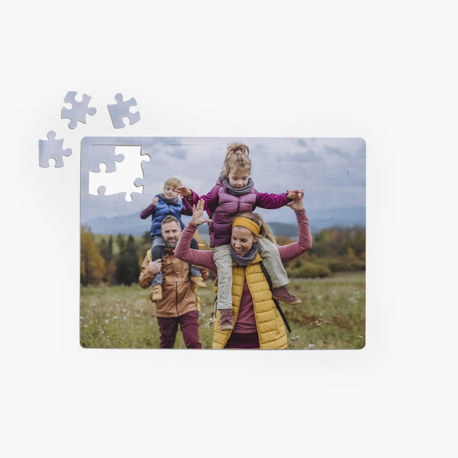 Ein selbst gestaltetes Puzzle mit dem Foto von Eltern und ihren beiden Kindern auf einer Wanderung. 