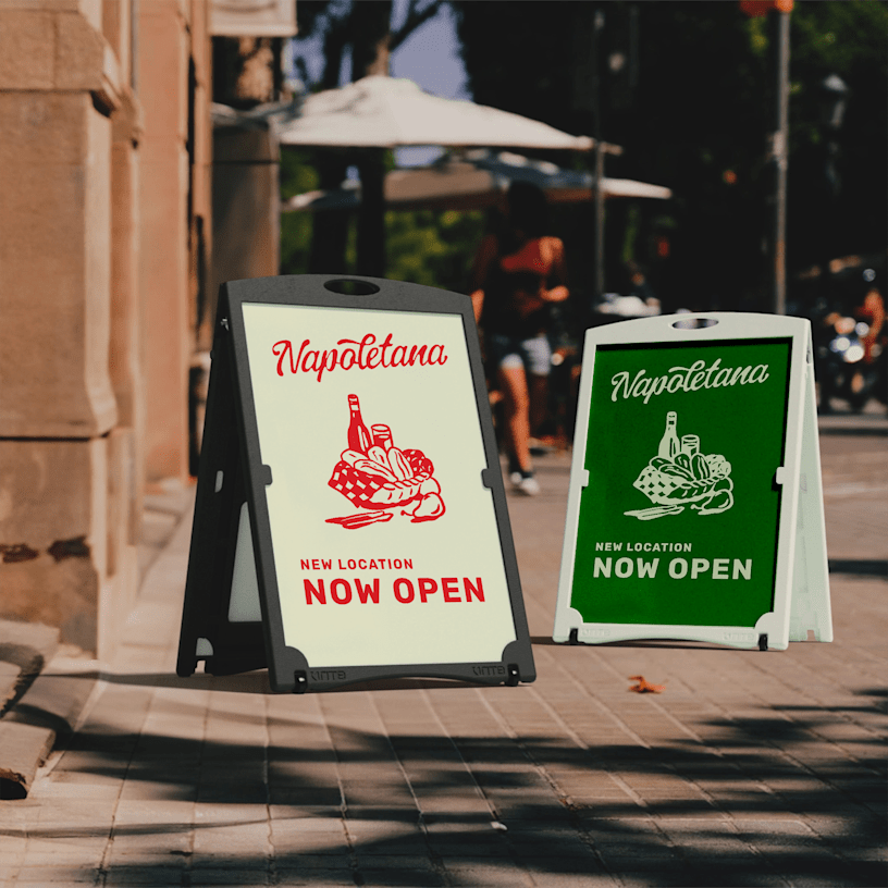 Water-fillable A-frames promoting a restaurant, displayed outdoors. One frame is black and one frame is white. 