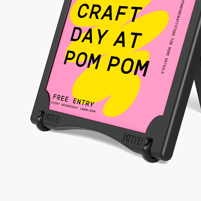 A close-up of a black water-fillable A-frame promoting a craft business, with one pair of wheels attached.