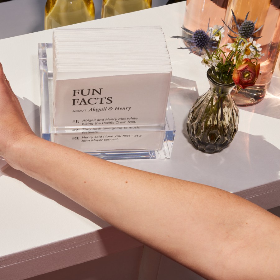 A collection of cocktail napkins personalized for a wedding, printed with fun facts about the bride and groom. 