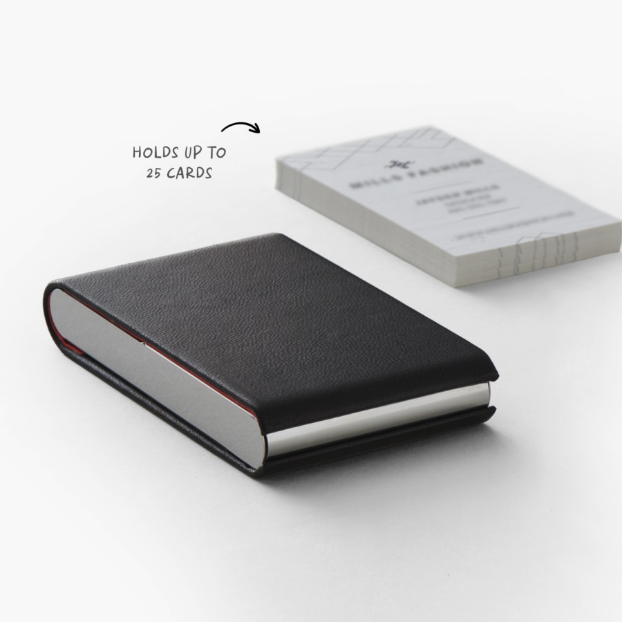 A black leather vertical business card holder next to a stack of 25 business cards, which is its maximum capacity.