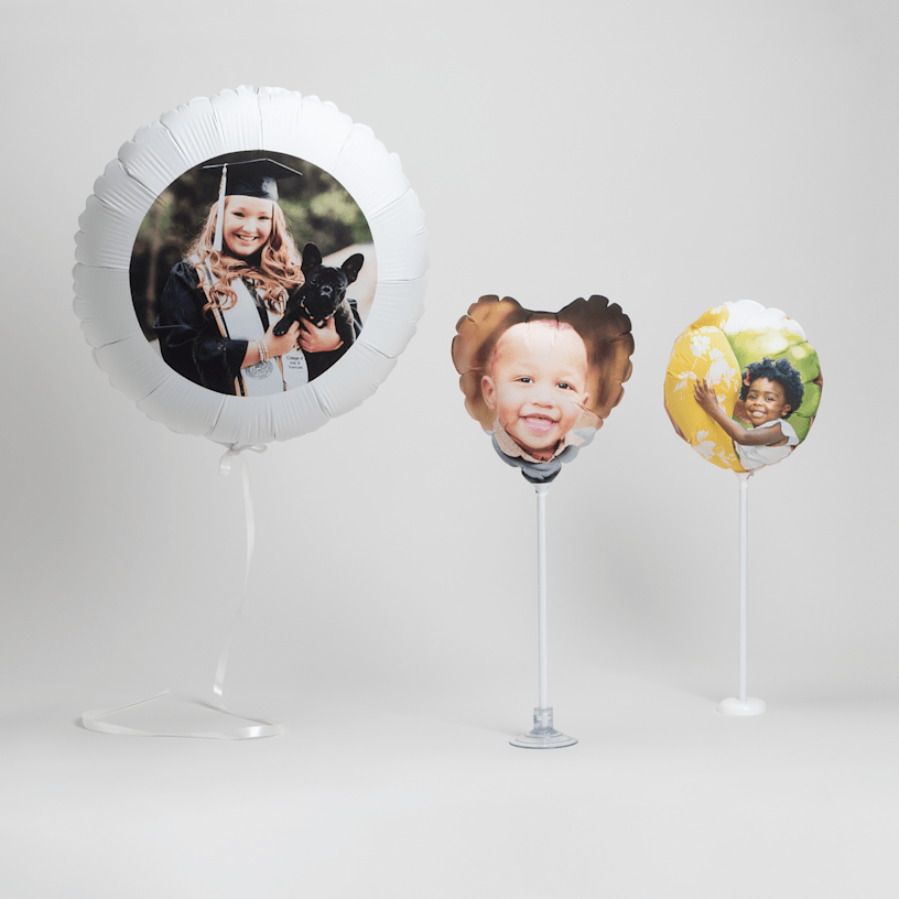 One 22" helium balloon, a 11" heart-shaped balloon with a stand and suction cup base and a 6" balloon with a plastic tabletop base.