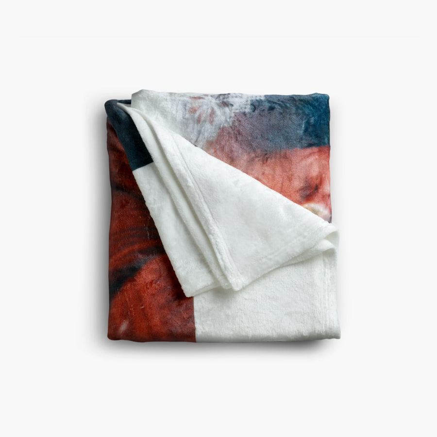 A personalized blanket folded into a square with one corner flipped out. 