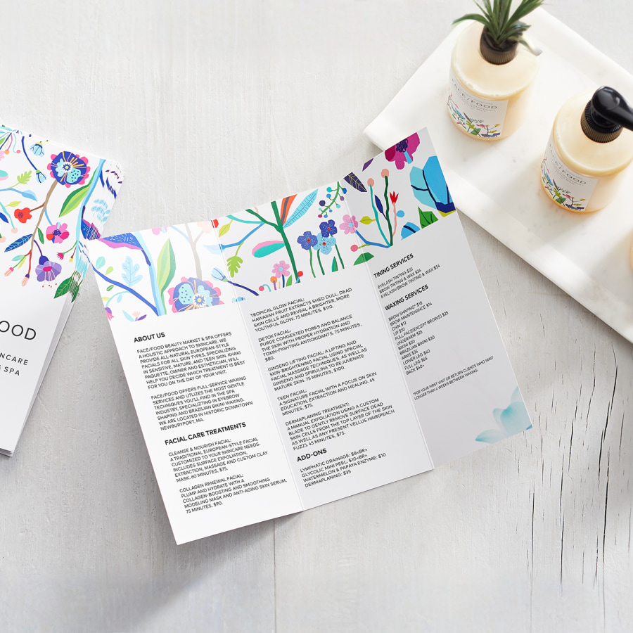 Tri-fold brochures for a skincare business, displayed on a white surface next to some skincare products.