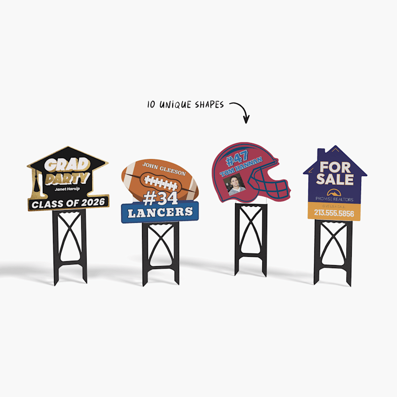 A grad hat, football, football helmet and a house yard sign on black plastic stands.