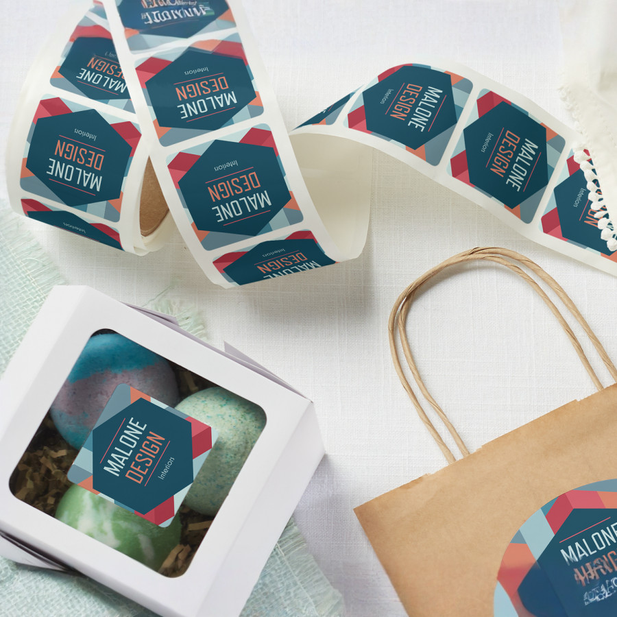 A roll of packaging labels from an interior design company, with a few placed on some bags and boxes.