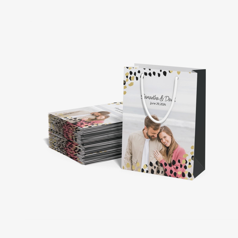 Shows a stack of flattened bags and one bag standing up next to them with a picture of a couple on a beach and the words Samantha and David printed.