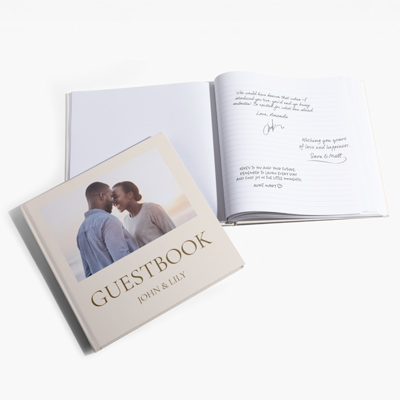 A stack of wedding guest books featuring the name of the couple and a botanical design. 