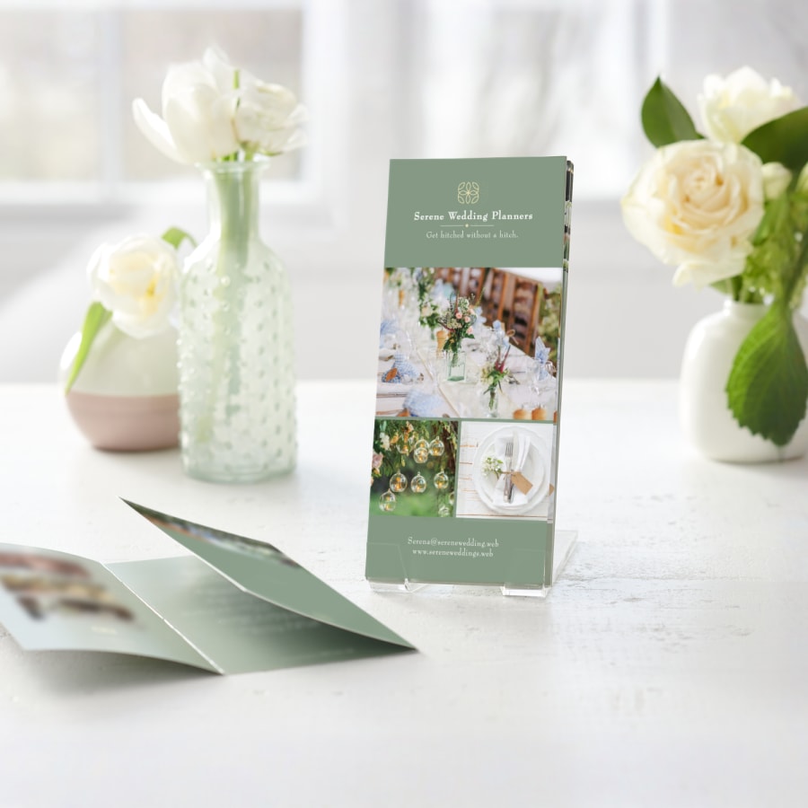 Several tri-fold menus for a wedding planning company, displayed in a clear plastic holder.  