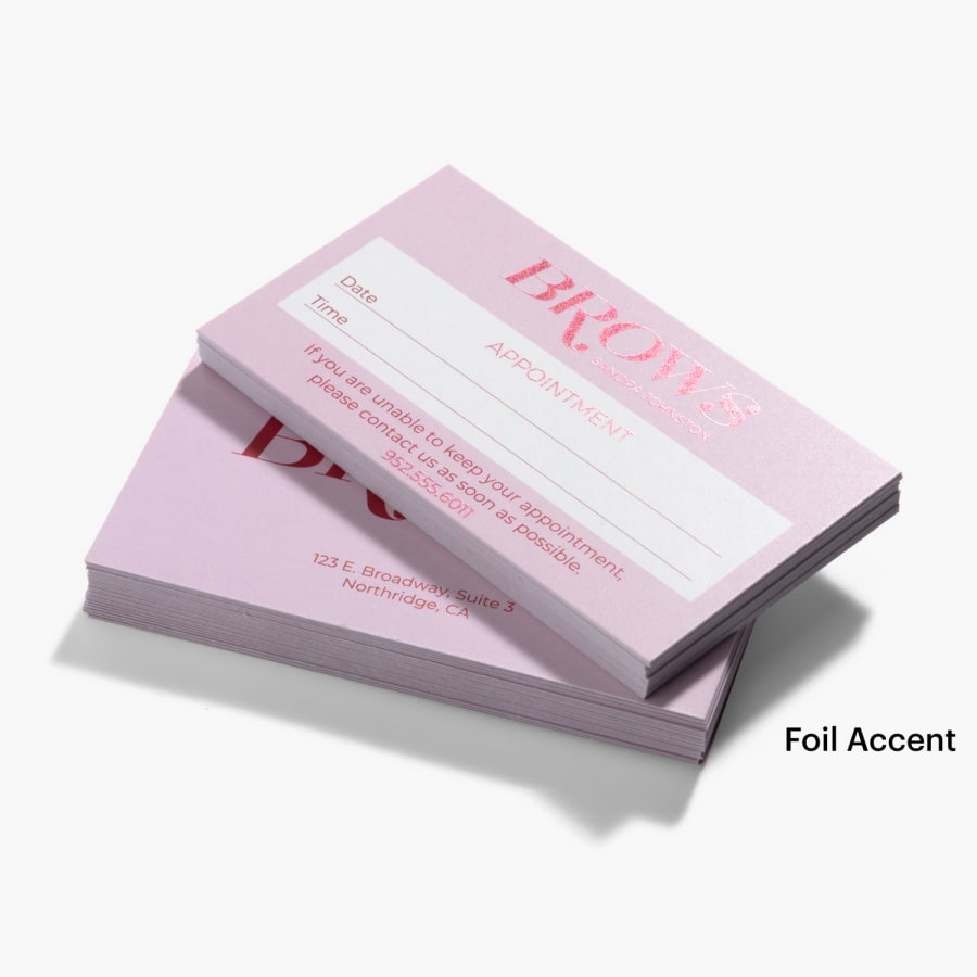 Two stacks of foil accent appointment cards for a beauty business, one showing the front and one showing the back.