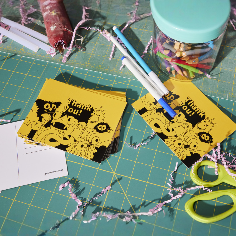 A stack of thank you postcards sitting on a crafting table.