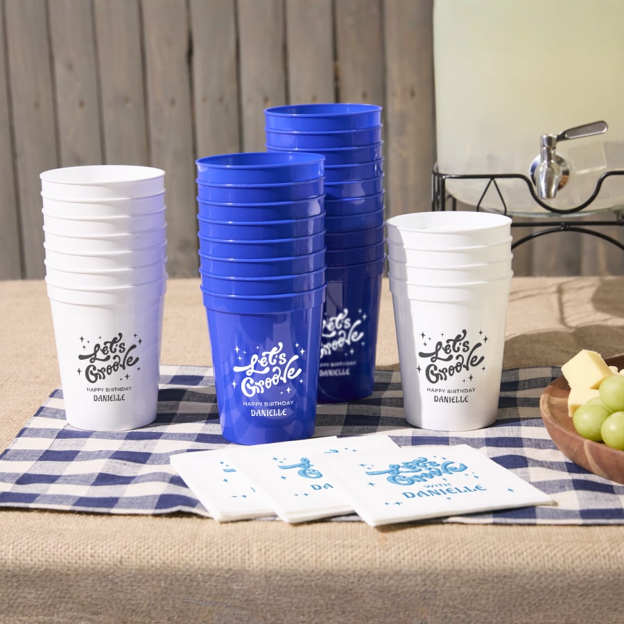 Custom stadium cups stacked on a party table, personalized with the message, “Let’s groove.”