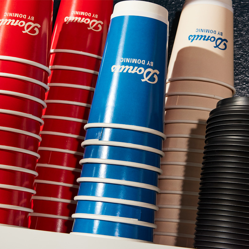 A variety of personalized disposable paper cups stacked on top of each other.
