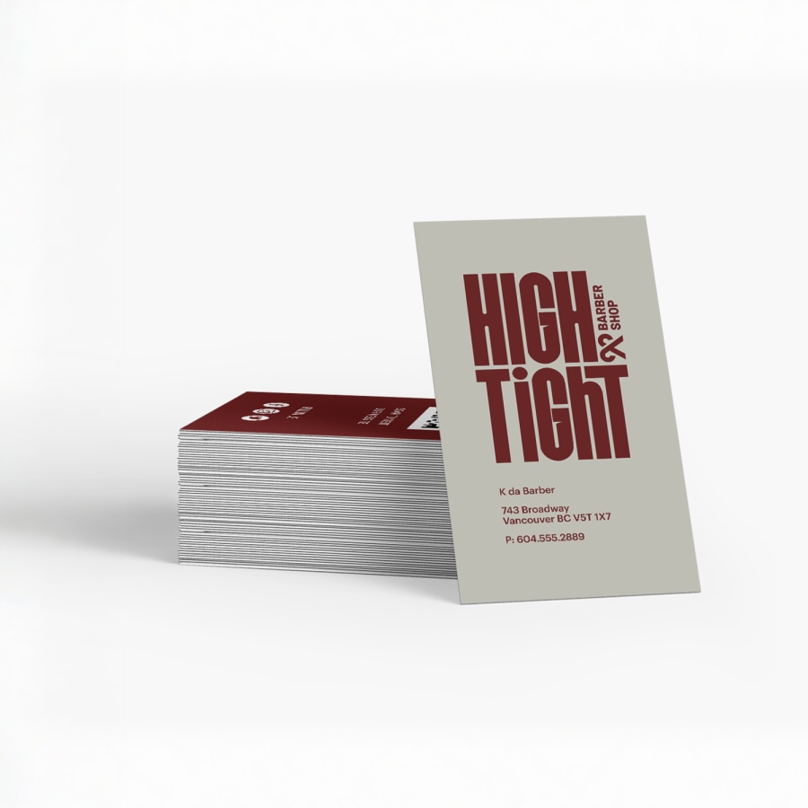 A stack of business cards for a barber, with one card standing upright.