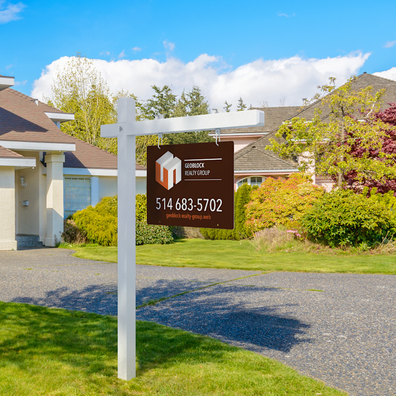 Real estate yard sign handing on a white colonial post.