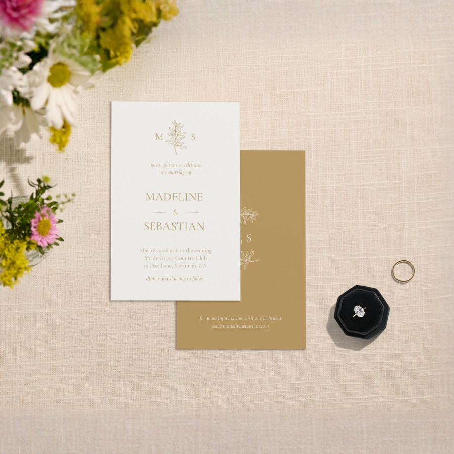 A custom wedding invite featuring a botanical-inspired monogram. 
