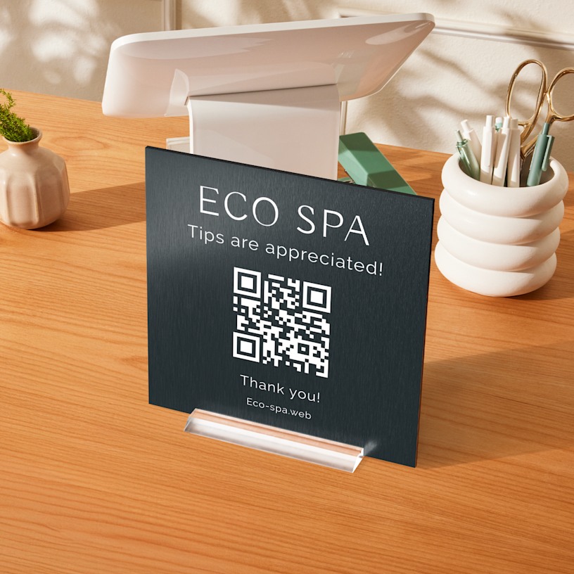 A spa metal table sign sharing a QR code for tips.