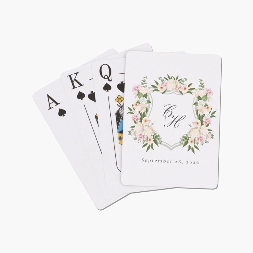 A stack of playing cards customized with a floral wedding monogram. 