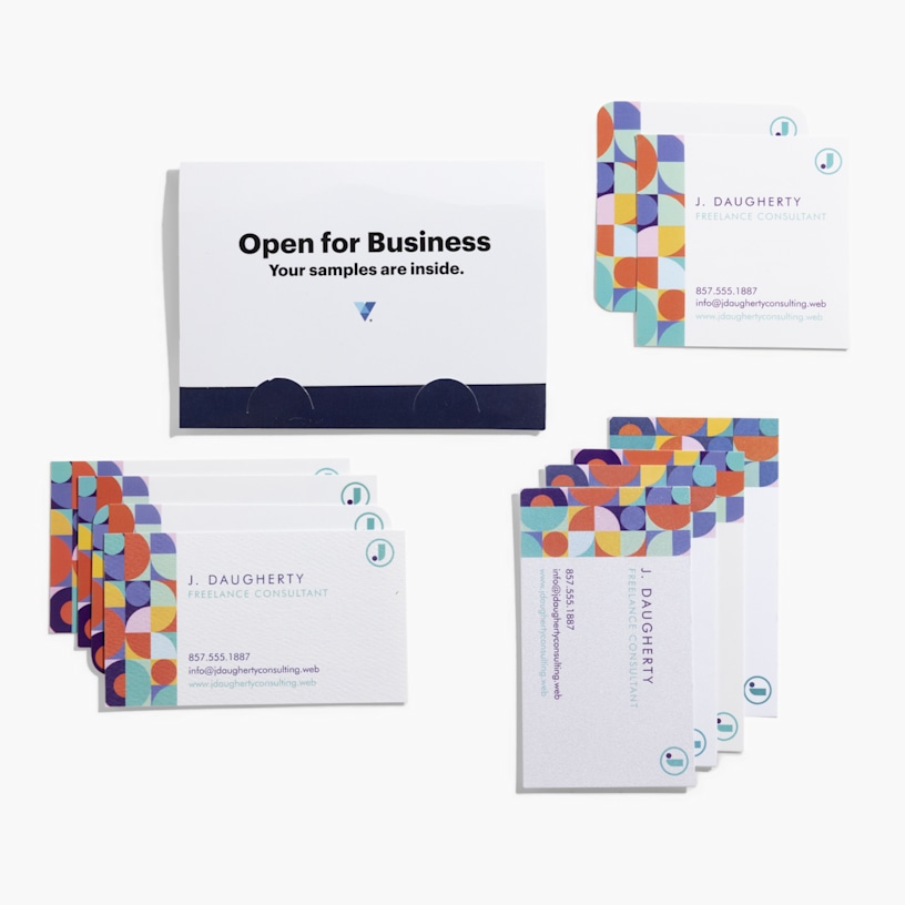 An overhead view of the business card sample kit, with stacks of business cards alongside a closed card holder on a white background.