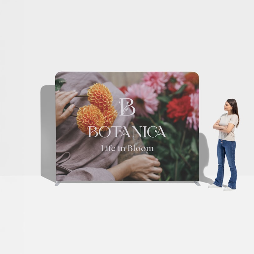  A woman standing next to a floral tension fabric display for scale.