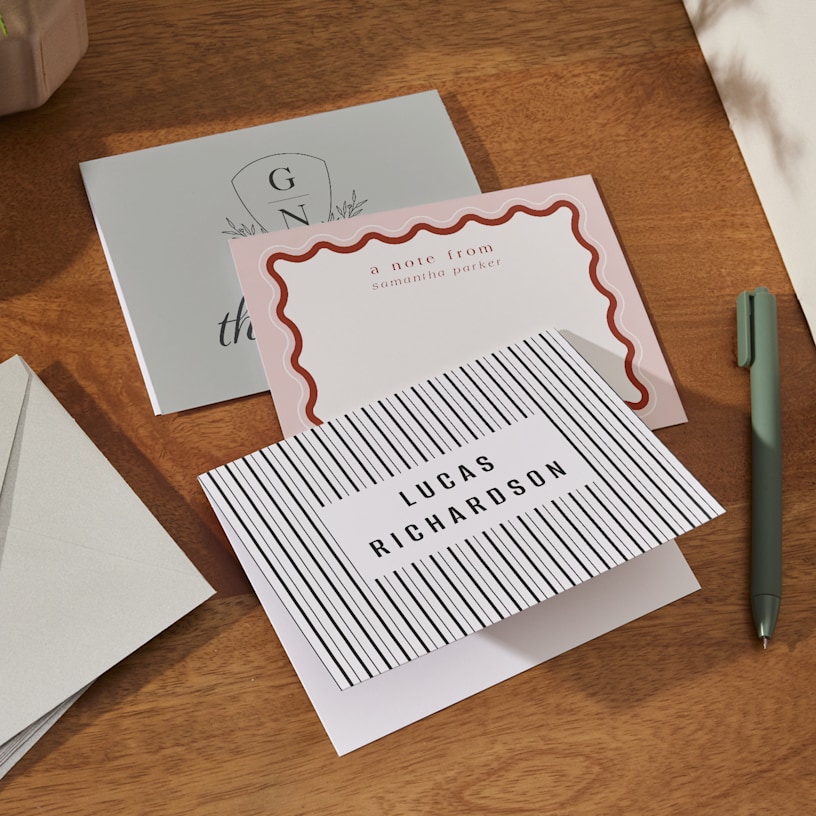 3 personalized note cards laid out on a table and featuring a variety of modern designs. 