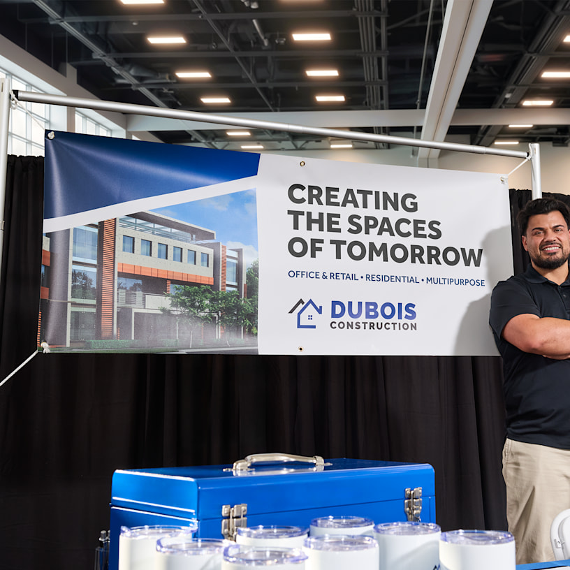 A vinyl banner promoting a construction company hanging up at a trade show.