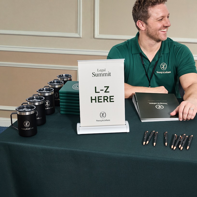  A tabletop retractable banner promoting a legal summit at a trade show.