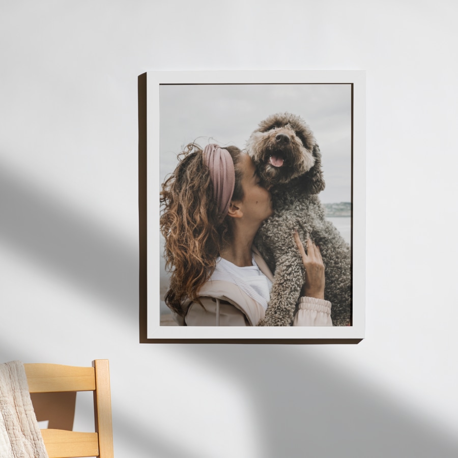 A white framed photo print with no border, featuring a photo of a woman and her dog. 