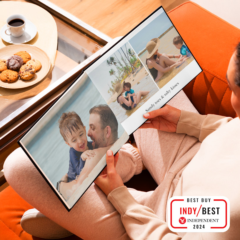 A photo book, open to pictures of a family beach holiday. 