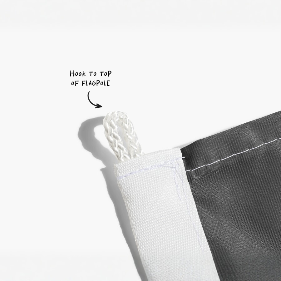 A close-up of a flag’s top string loop, with a note saying to attach this part to the flagpole.