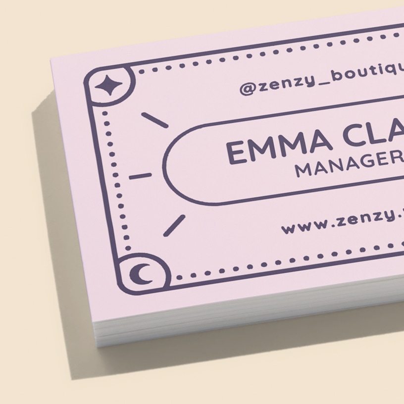 A close-up view of a stack of soft touch business cards showcasing a boutique shop.