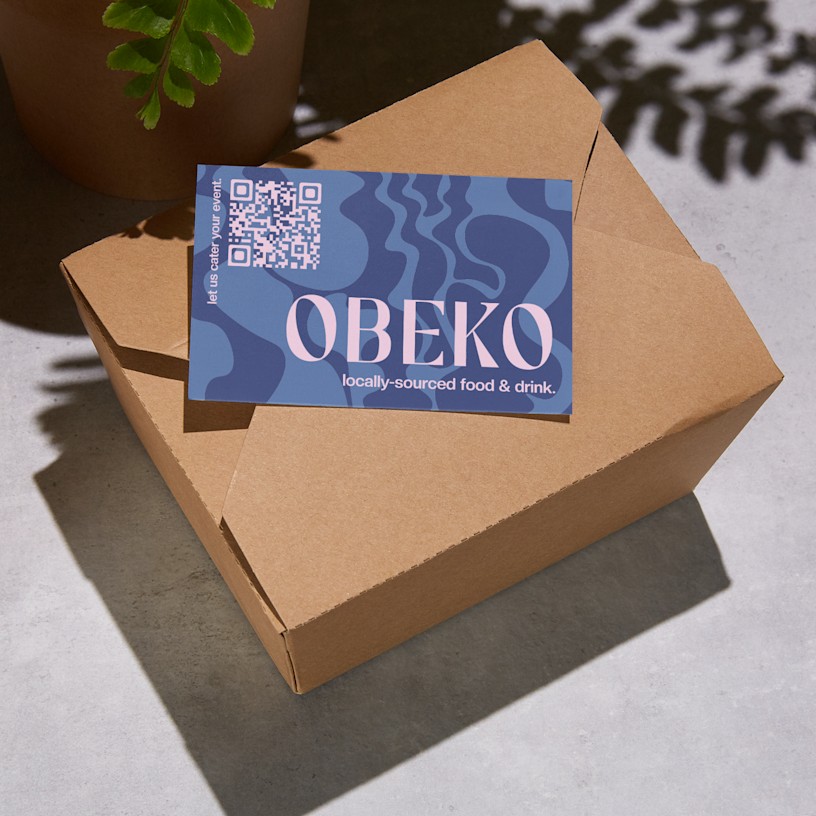 A QR code business card for a ceramics business is shown placed on a takeaway box.