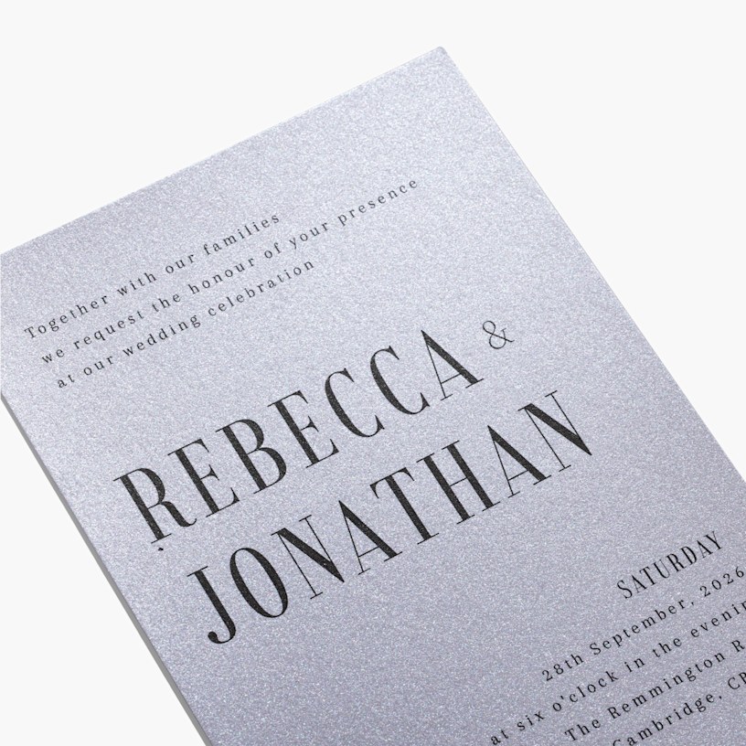 A custom wedding invitation printed on shimmery paper stock and customised with a bold font. 
