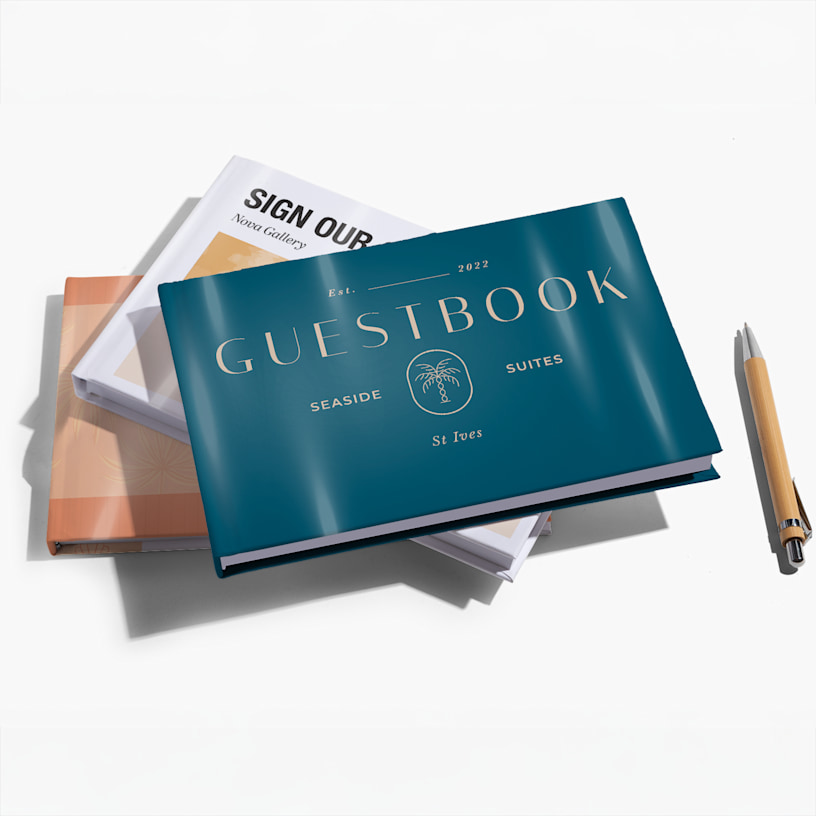 A stack of guest books, one printed with the name of a hotel on the cover and the other with the name of an art gallery. 