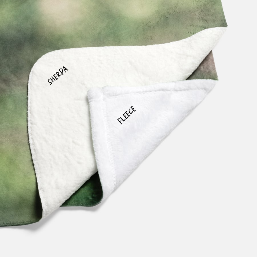 Corners of two different blankets folded over to show different materials: personalised fleece blanket and personalised sherpa blanket.