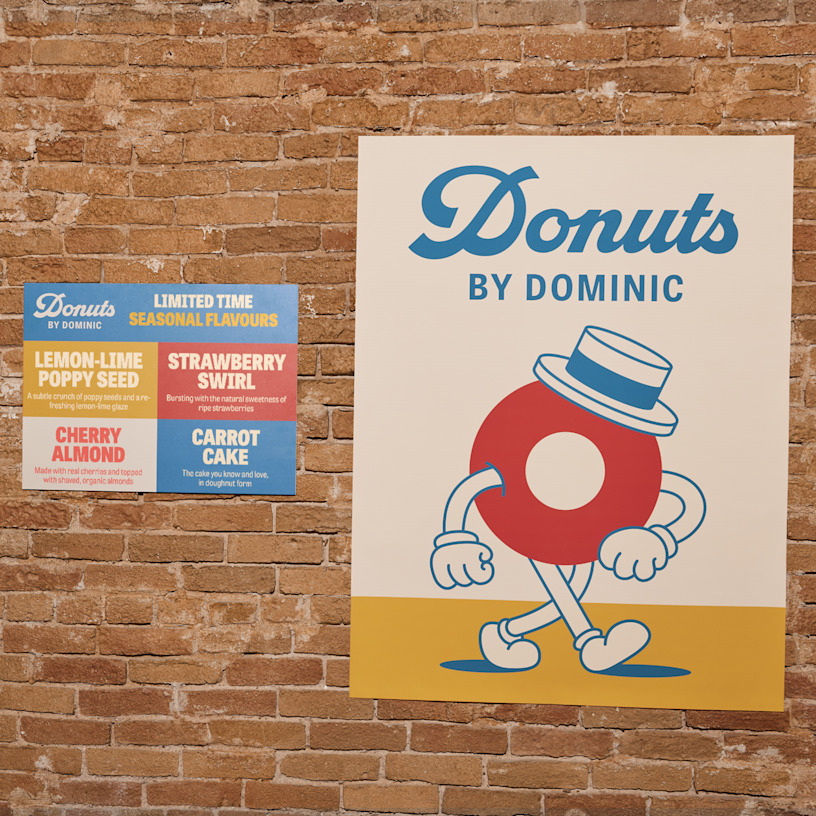 A wall featuring custom size posters promoting a food and beverage business.