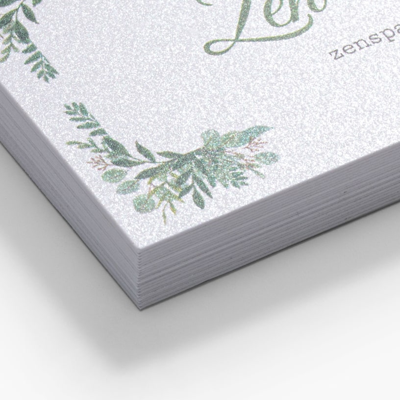 Close-up view of a stack of pearl business cards with sharp square corners, showcasing their shimmering effect.