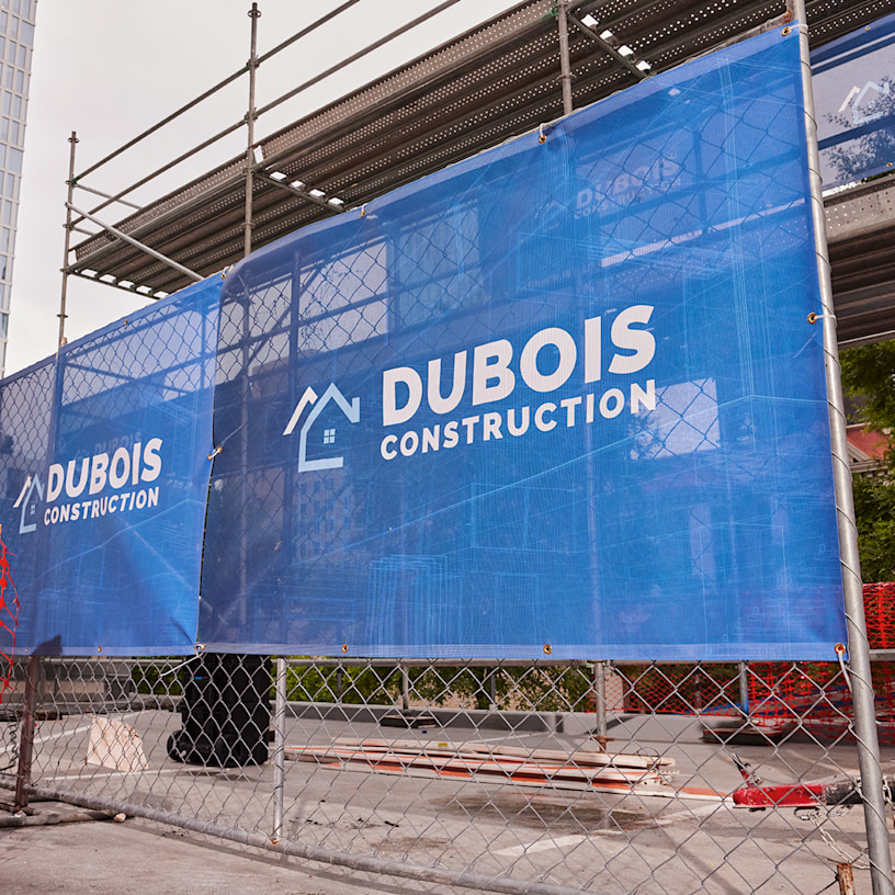 A horizontal mesh banner promoting a construction business.