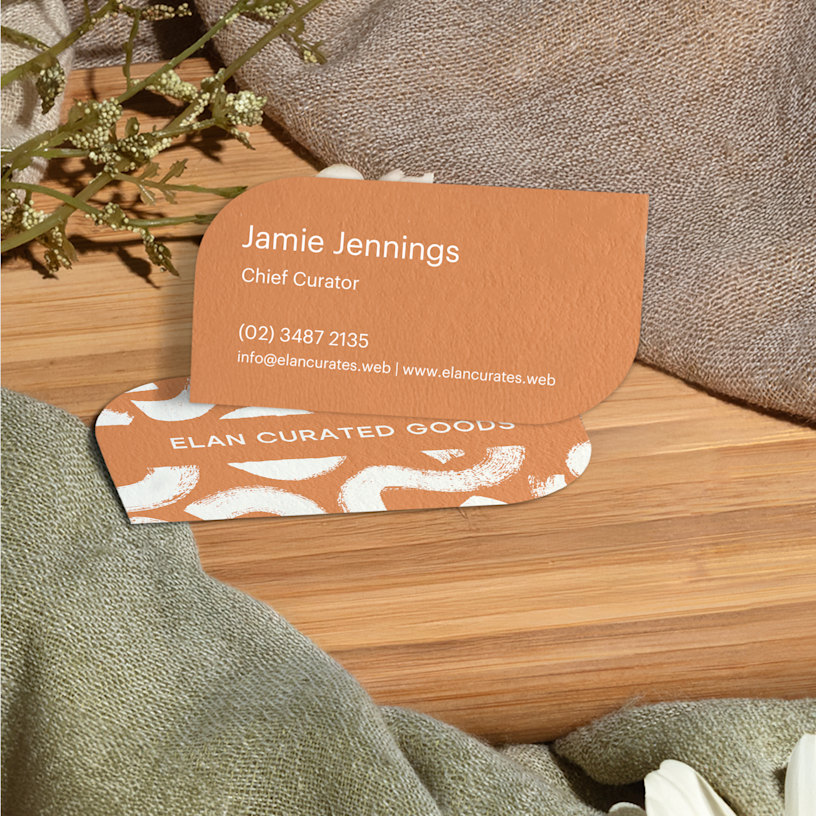 Leaf shaped business cards promoting a curator’s services, displayed on a counter.