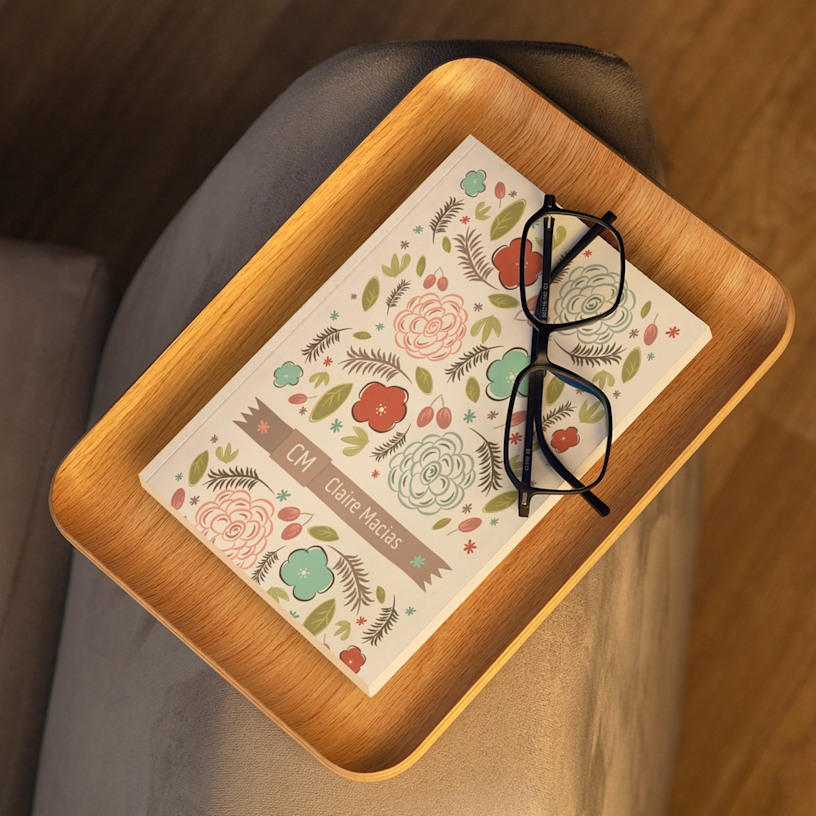 A perfect bound notebook with an illustrated cover featuring a person's monogram.