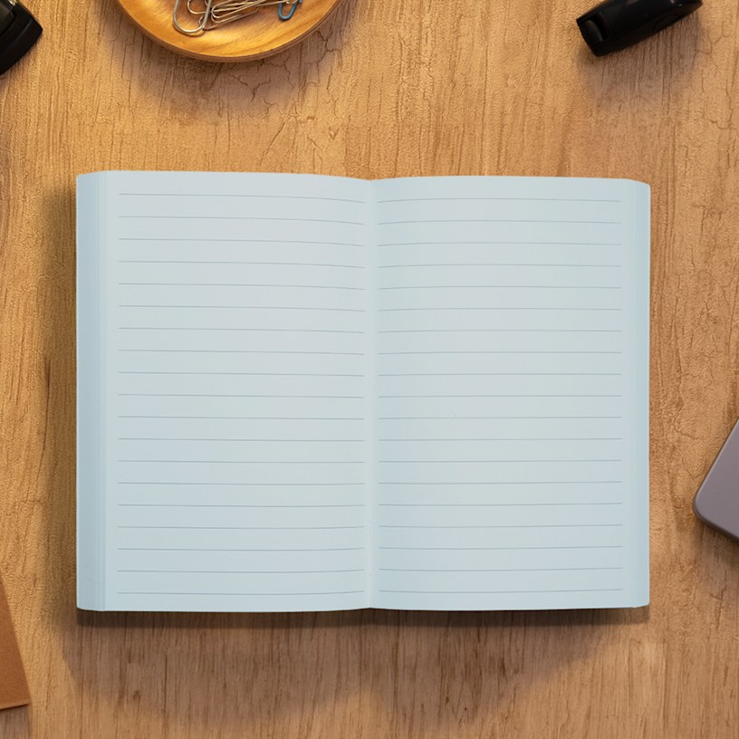 A perfect bound notebook on a table with a daily planner inner page style.