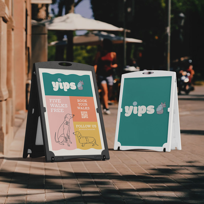 Two water-fillable A-frames promoting a dog walking business, displayed outdoors. One features a QR code for bookings, while the other features the business name and logo.