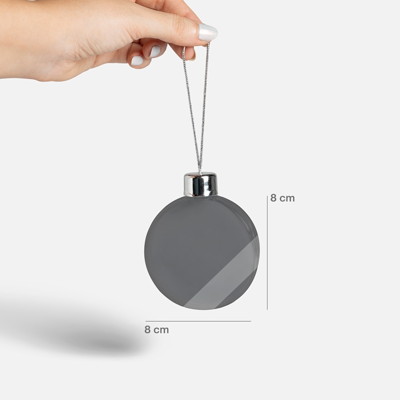 A person holding up a Christmas bauble, measuring 8 x 8 cm.