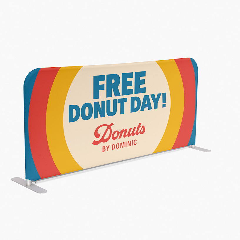 An event barrier promoting a donut shop, featuring stylised text and a logo. 