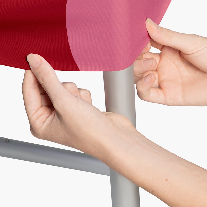 A closeup of a person stretching the fabric over the frame. 