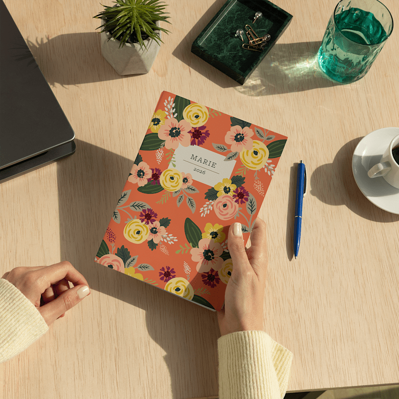 A custom wraparound spiral notebook with floral illustrations and a person's name on the cover.
