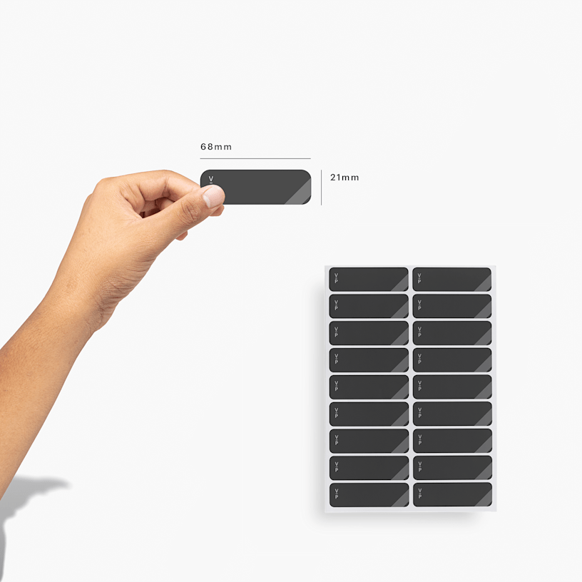 A person holding up return address labels from the sheet format, measuring 68 x 21 mm.