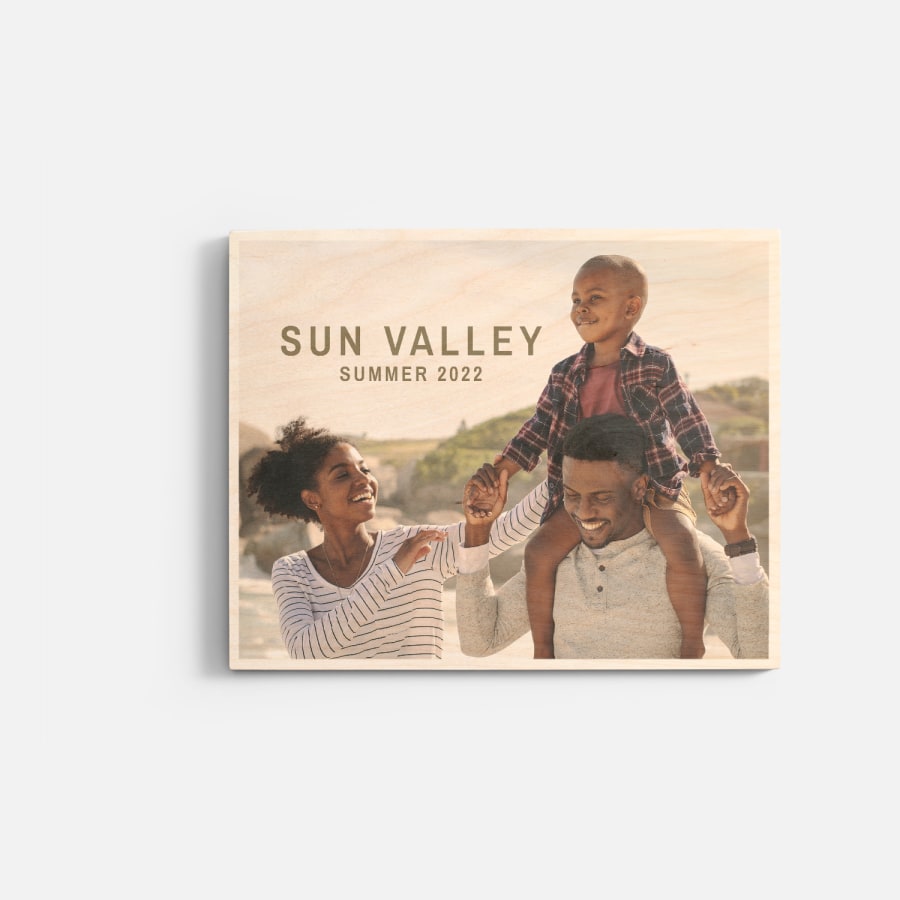 A custom wood print featuring a photo of a young couple and their child.  