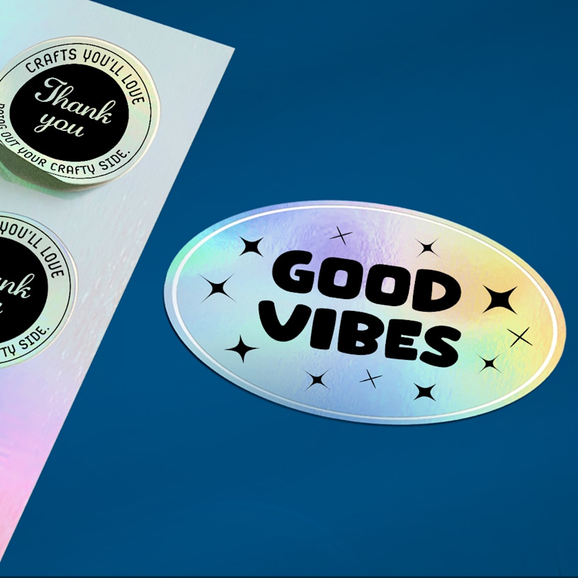 A sheet of holographic “thank you” stickers alongside a single oval holographic sticker.